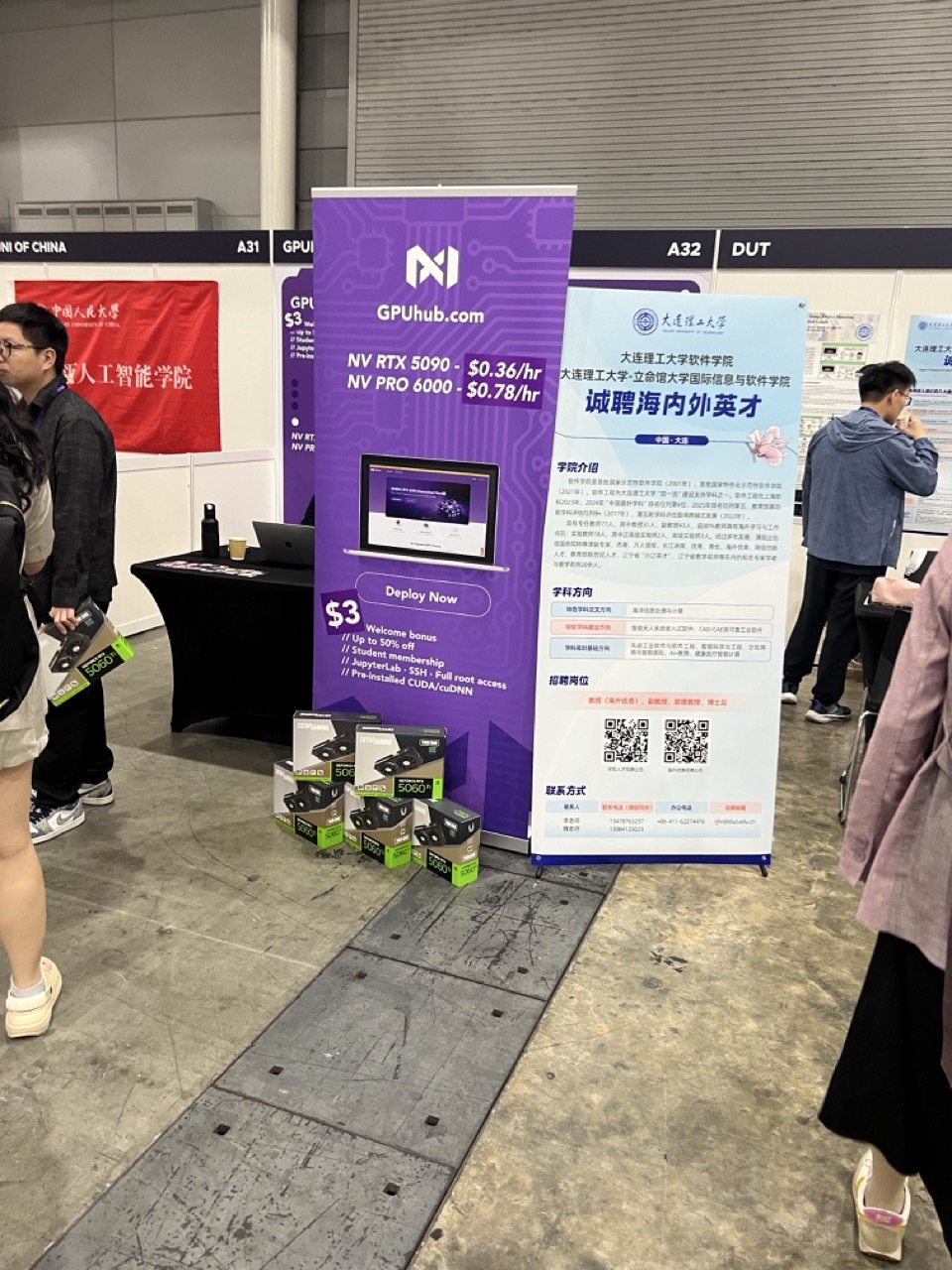 Conference booth advertising GPU rental with pricing and QR codes.